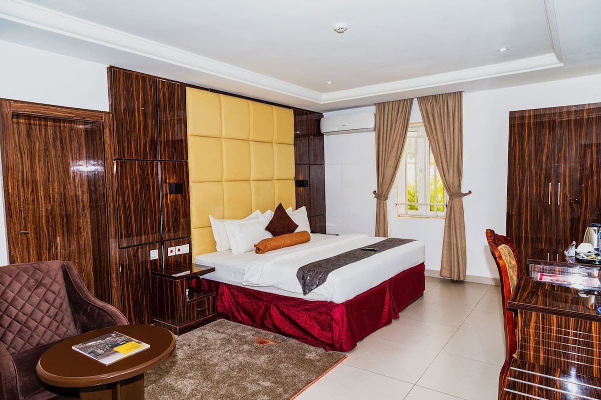 Ein Hotelzimmer mit Bett, Schreibtisch, Stuhl und Kleiderschrank.
