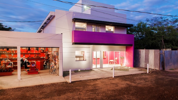 A modern two-story building with a ground-level retail space and a second-floor residential unit. - Airport Inn Managua (Managua)