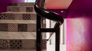 A staircase with patterned tiles and a black handrail. - Airport Inn Managua (Managua)