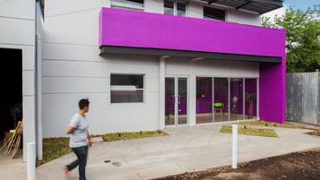 A modern building with a white facade and a purple section.