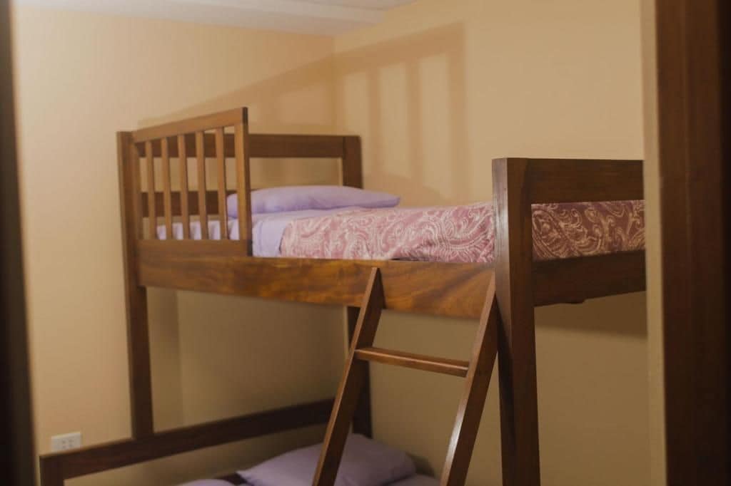 A bunk bed with a ladder, a pillow, and a patterned bedspread.