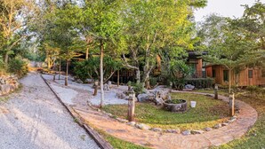 Una cabana de fusta rústica envoltada d'un jardí amb un camí de pedra que hi convergeix.