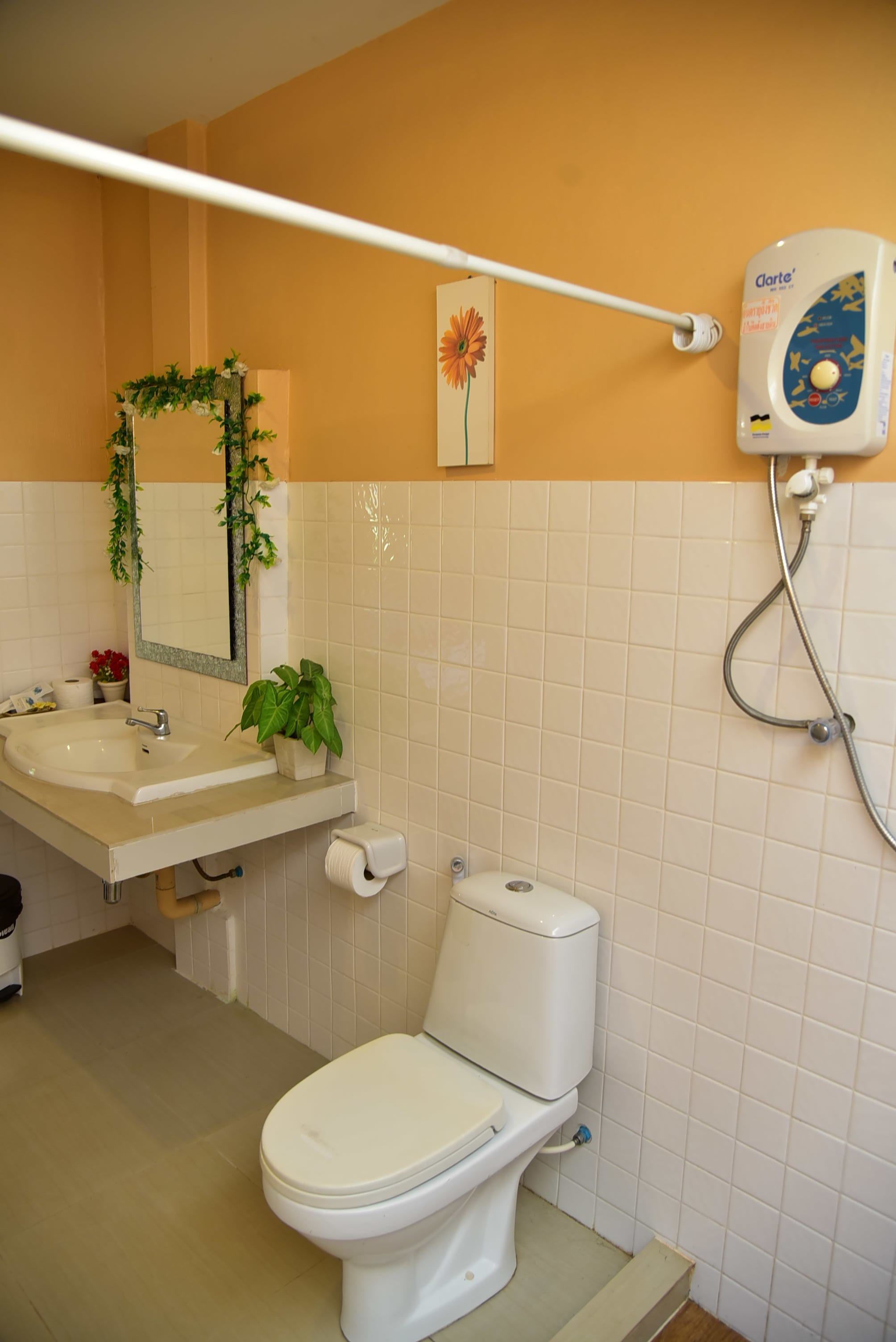 A bathroom with a toilet, sink, and shower.