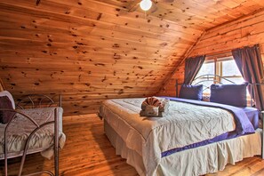 Een gezellig kamer in een chalet, met een bed, een stoel en een raam met gordijnen.