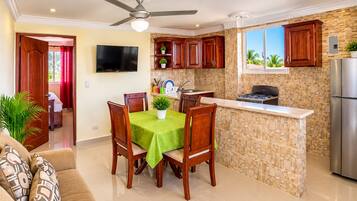 A modern kitchen with a central island, wooden cabinets, a built-in stove, and a stainless steel refrigerator.