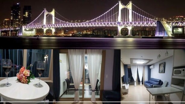 Hotel Maritimo Beach House com vista para uma ponte à noite. O hotel possui uma sala de jantar com mesa e cadeiras, e uma sala de estar com sofá e televisão.