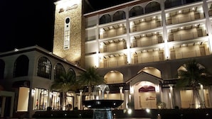 Un hotel de varios pisos con un patio central, una fuente y una torre.