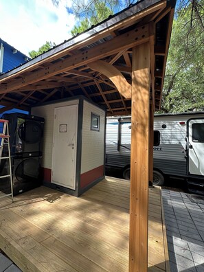 Enjoy outdoor activities on the covered deck with a washing machine and compact refrigerator nearby.