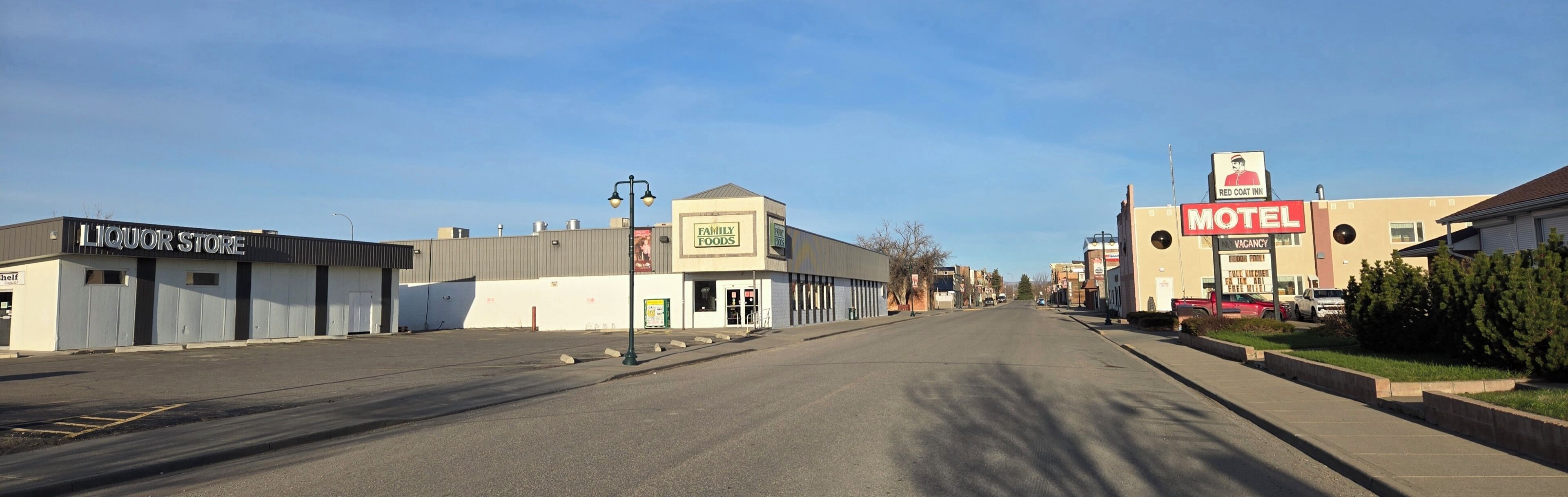 A street with a liquor store, a family foods restaurant, and a motel.
