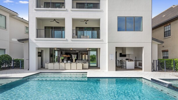 A modern building with a swimming pool, balconies, and a bar area. - Modern Estate | 8,400 sq ft Luxury Villa with Games Room, Private Pool & Spa (Kissimmee)