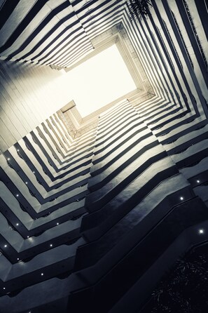 A spiral staircase with a geometric pattern and a central light source.
