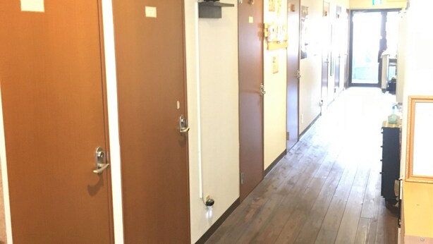 A hallway with wooden floors and doors numbered 6 to 7. - Kagoshima Little Asia - Hostel (Kagoshima)