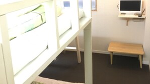 A room with bunk beds, a small desk with a computer, and a window. - Kagoshima Little Asia - Hostel (Kagoshima)