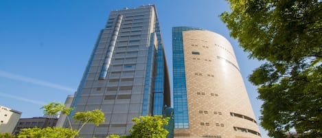 A modern building with a glass facade and a cylindrical structure.