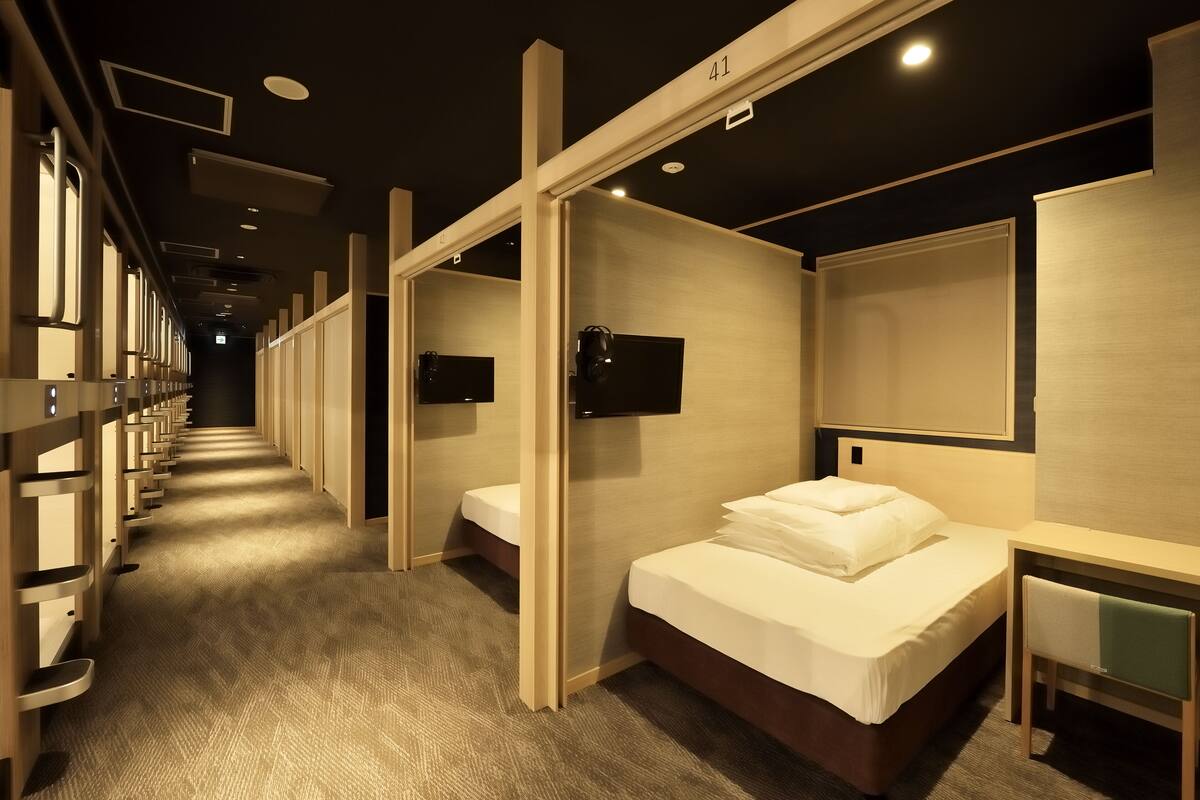 A hotel room with a bed, a desk, and a TV.