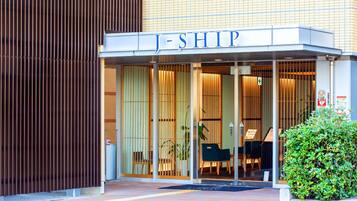 A hotel entrance with a name sign 'J-SHIP'.