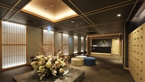 A modern hotel lobby with a central floral arrangement, seating areas, and a reception desk. - HOTEL J-SHIP OSAKA NAMBA (Osaka)