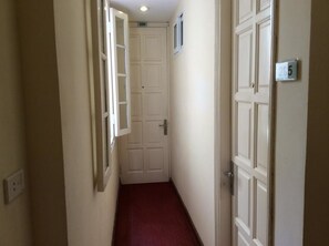A narrow hallway with white doors, numbered 206 and 205, leading to rooms.