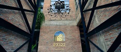Una escalera de ladrillo que conduce a la entrada de un hotel, con una araña y un letrero que dice "KONLOGPA PX122 ABEST HOTEL".