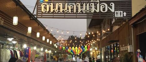 A market street with shops and hanging lanterns.