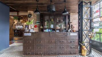 A reception desk with multiple drawers, a clock, and a window with a view of the outside.