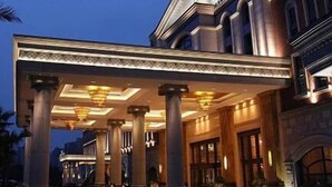 A grand hotel entrance with classical architecture, featuring large columns and a covered walkway. - Chongqing Auwi Hotel (Chongqing)