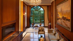 A spacious lobby with a grand chandelier, a large arched window, a sofa, and a painting on the wall. - Chongqing Auwi Hotel (Chongqing)
