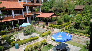 Ein Innenhof mit Sitzgelegenheiten im Freien, einem Pepsi-Sonnenschirm und einem gepflasterten Weg.