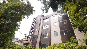 A multi-story building with a modern architectural style, featuring a mix of brown and beige exterior walls and multiple windows. - Hotel Paradise Inn (New Delhi)