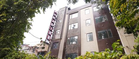 A multi-story building with a modern architectural style, featuring a mix of brown and beige exterior walls and multiple windows.