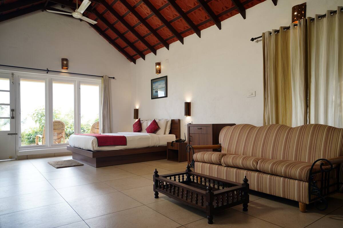 A spacious living room with a large sofa, a bed, and a coffee table.
