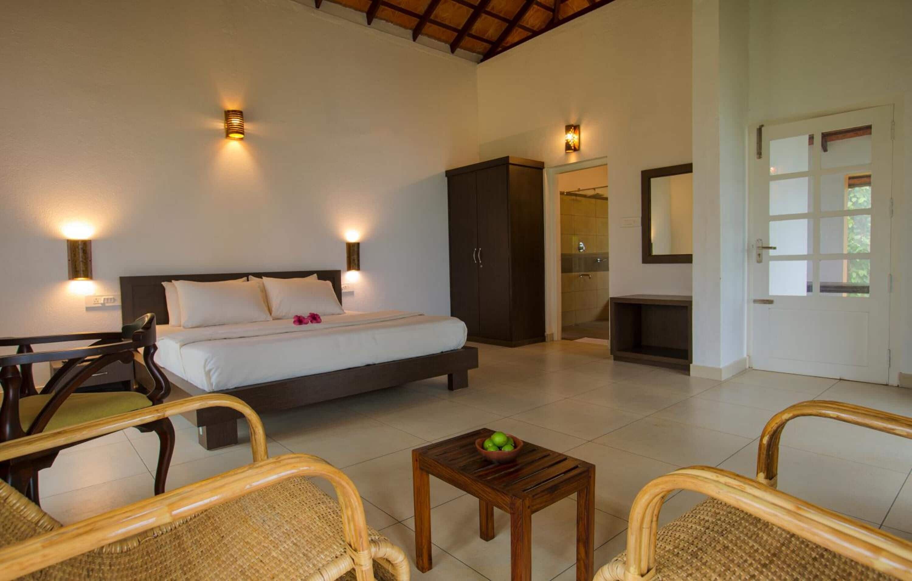 A bedroom with a bed, bedside tables, a wardrobe, and a bathroom visible through an open door.
