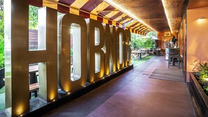 A covered outdoor area with a large illuminated sign reading "HORN". - Infiniti Hotel & Spa (Indore)