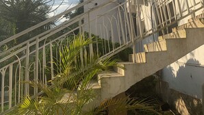 A staircase leading to a building with a white exterior and metal railing. - HighLander Guest House (Aburi)