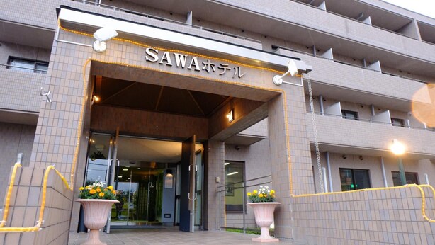 The entrance to a building with a sign reading "SAWAホテル". - Sawa Hotel (Fujikawaguchiko)