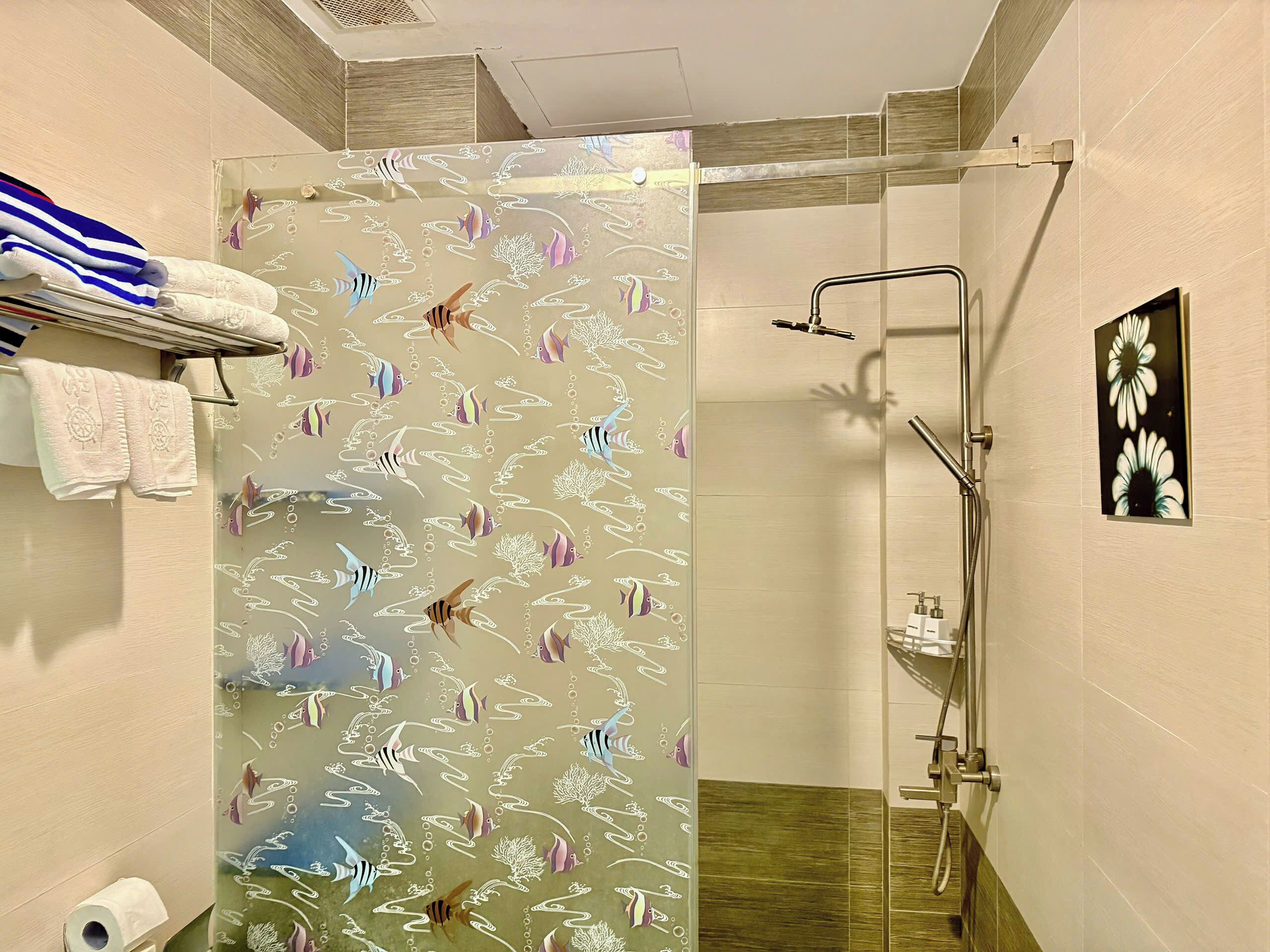 A bathroom with a shower, a towel rack with towels, a toilet, and a sink.