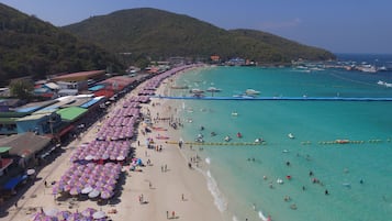 Di pantai, kursi berjemur, payung pantai, dan handuk pantai