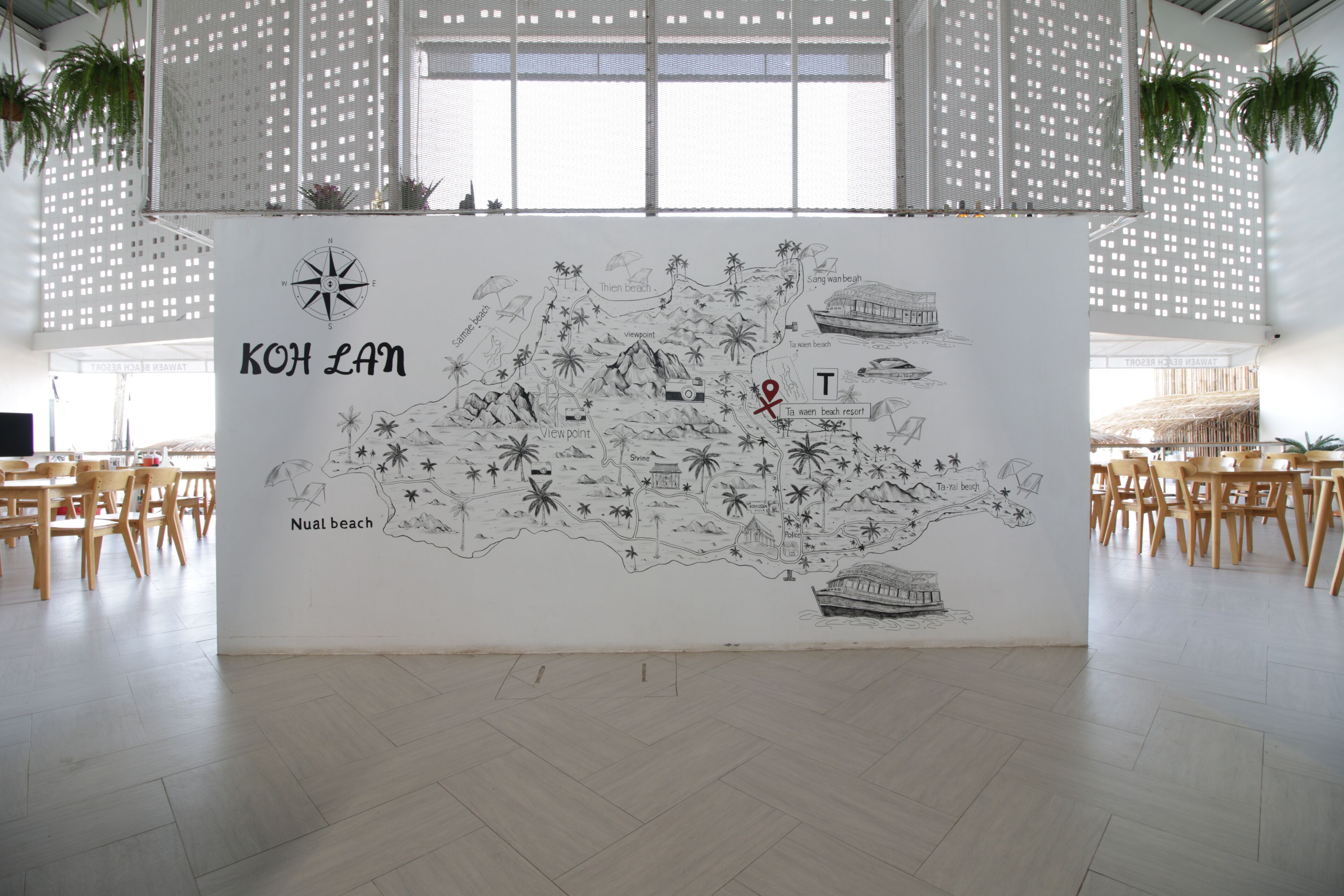 A wall with a map of Koh Lan, including landmarks like Nual Beach and Ta Wa Beach.