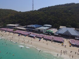 A beach with umbrellas and people.