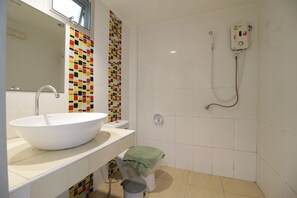 A bathroom with a large white sink, a toilet, a shower with a control panel, and a colorful mosaic wall. - Tawaen Beach Resort (Koh Lan)
