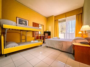A room with bunk beds, a single bed, a desk with a chair, a TV, and a window with curtains. - Rèmin Plaza Hotel (Rimini)
