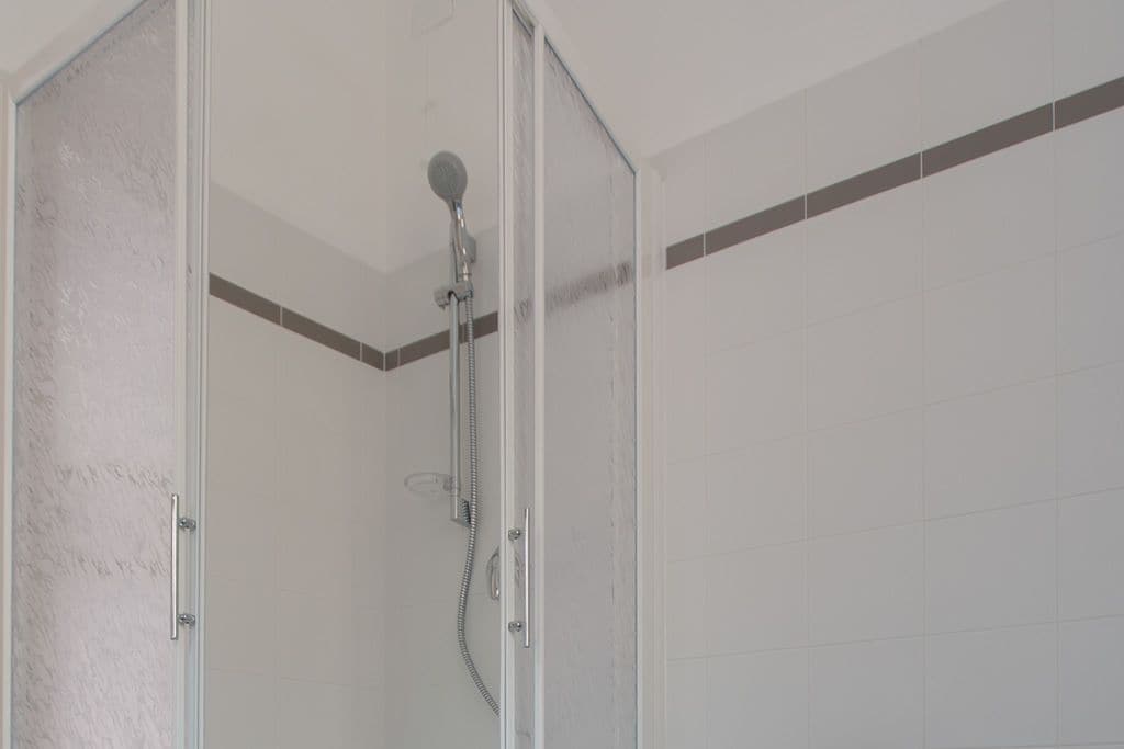 A shower area with a glass door and a showerhead.