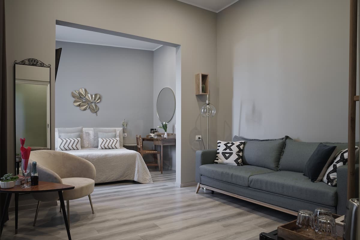 Un salon moderne comprenant un canapé, un fauteuil, un lit et un bureau.