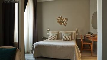 A bedroom with a bed, a desk, a chair, and a wall-mounted mirror.