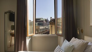 A bedroom with a large window, a bed with pillows, a mirror, and a wall-mounted light fixture. - B&B My Way (Florence)