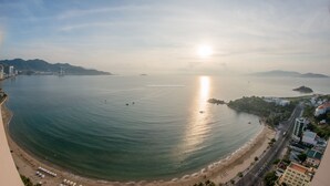 A coastal cityscape with a beach, buildings, and a clear sky. - Handy Beachfront Apartment (Bac Nha Trang)