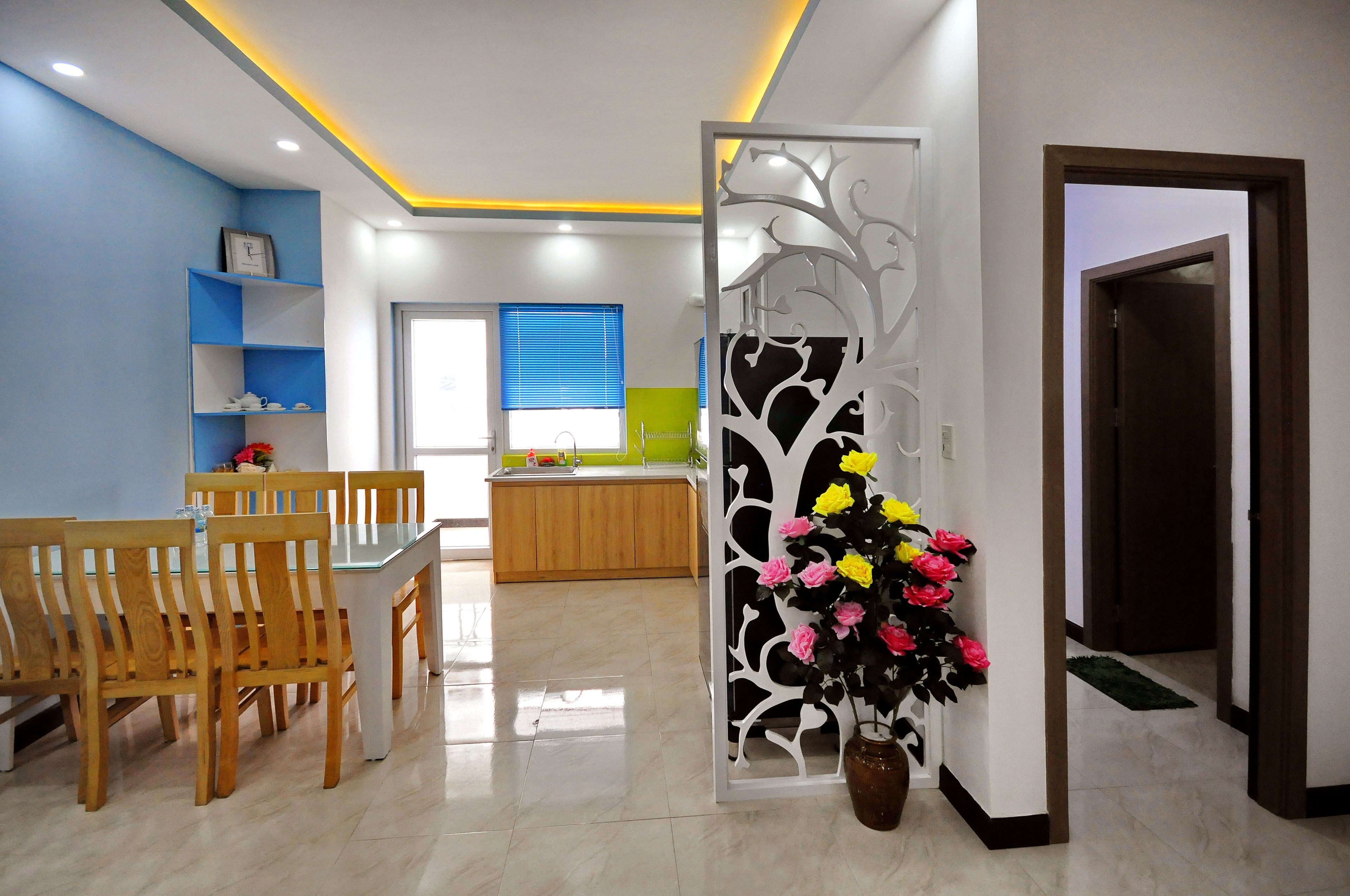 A modern kitchen with a wooden countertop and a window with blinds.