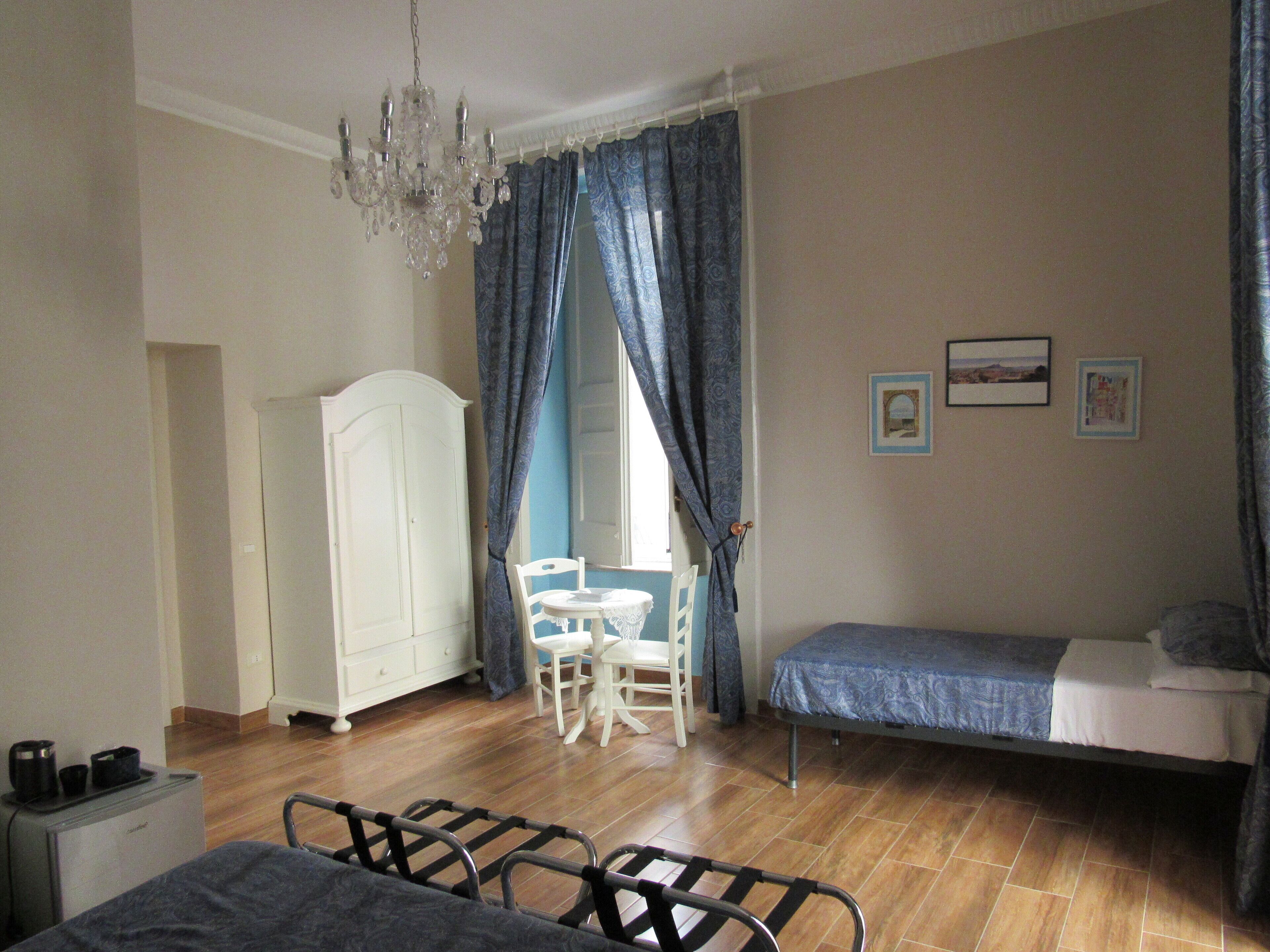 Una camera da letto con un letto, una scrivania, una sedia, un armadio e un lampadario.