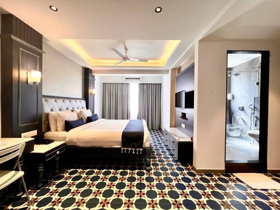 Una habitación de hotel con cama, mesita de noche y televisión.