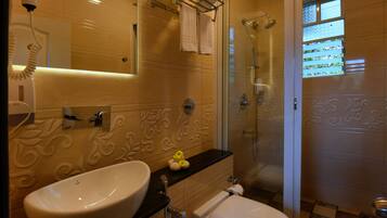 Un baño con lavamanos, inodoro y ducha.